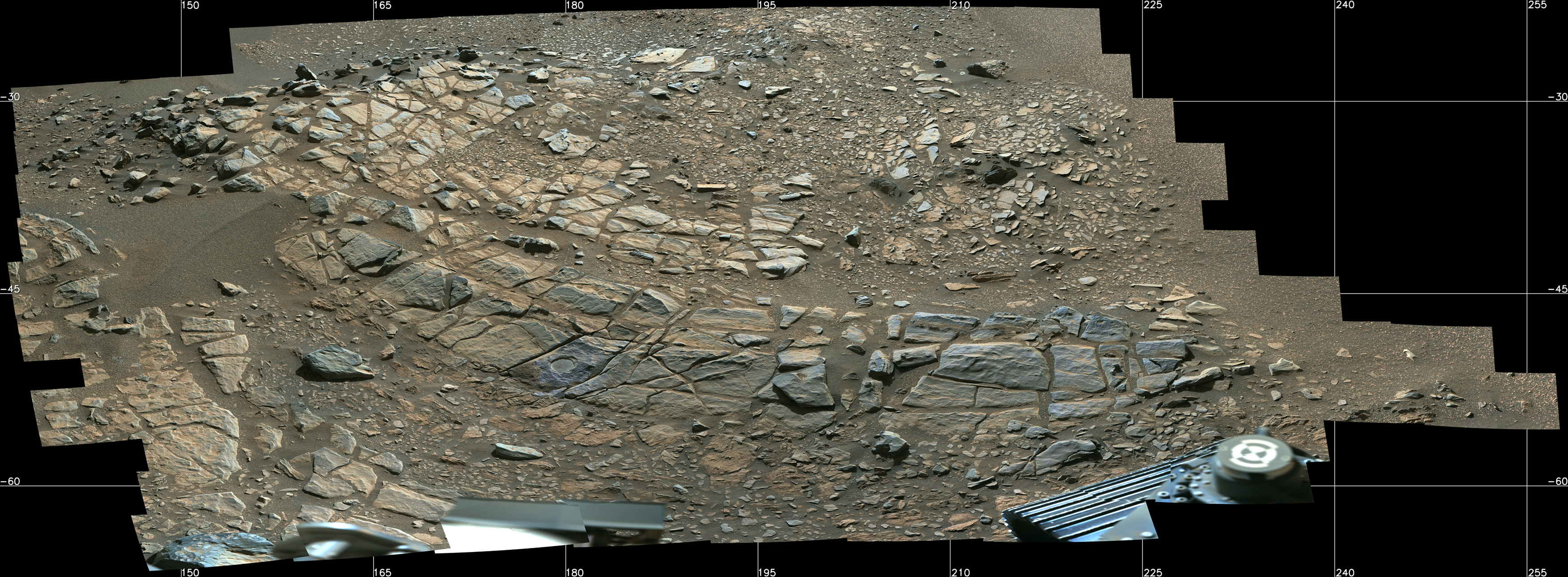 Photos show the Martian surface, filled with shards of rocks in grey and tan.