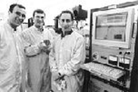 MIT researchers have developed a microchip that releases chemicals on demand. Here Professor Michael Cima, Graduate Student John Santini, and Professor Robert Langer stand in the MIT Microsystems Technology Laboratory where the chip was fabricated. Mr. Santini holds a silicon wafer containing 21 of the dime-sized chips.