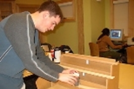 Will Etheridge sets up a beam-bending demonstration using a solid piece of wood (top), five bonded wooden strips (middle) and five unbonded strips.