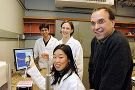 A team of MIT researchers is working on an implantable chip that can track whether a person is responding to cancer chemotherapy treatment. Standing, from left to right, are graduate student Christophoros Vassiliou, graduate student Karen Daniel and Michael Cima, professor of materials science and engineering. Seated in front is graduate student Grace Kim.