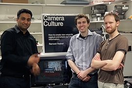 Associate Professor Ramesh Raskar, left, postdoc Douglas Lanman, center, and graduate student Matthew Hirsch flank the prototype of their new glasses-free 3-D video system.