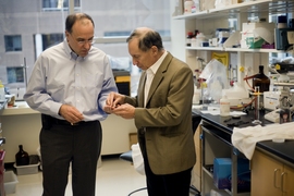 Professors Robert S. Langer (right) and Michael J. Cima speak in the Cima Lab at the David H. Koch Institute for Integrative Cancer Research at MIT. Langer and Cima work together in biotechnology and have developed a new implantable medical device which allows repeated wireless drug delivery in lieu of injections.