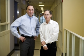 Professors Robert S. Langer (right) and Michael J. Cima speak in the Cima Lab at the David H. Koch Institute for Integrative Cancer Research at MIT. Langer and Cima work together in biotechnology and have developed a new implantable medical device which allows repeated wireless drug delivery in lieu of injections.