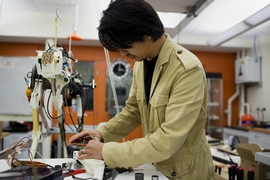 Assistant Professor Sangbae Kim works on the 70-pound 'cheetah' robot designed at MIT.