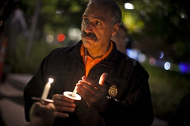 John DiFava, MIT&#8217;s director of facilities operations and security, holds a candle during the moment of silence to honor slain MIT Officer Sean Collier.