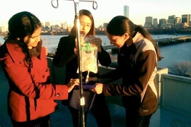 Gururaj and teammates test a device to warm IV fluid on the balcony of the McCormick Hall penthouse to see how the device performs in colder environments.