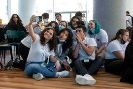 A group of students huddle together taking a selfie photograph