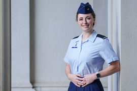 Liberty Ladd wears her Air Force ROTC uniform while standing outside next to a stone building at MIT