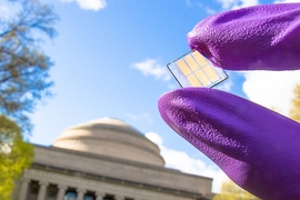 Researcher displays a sample of the record-setting new solar cell on the MIT campus.