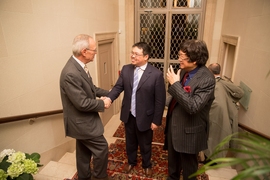 MIT President L. Rafael Reif greets Samathur Li (center) and Samuel Tak Lee at Gray House, where the signing ceremony was held.