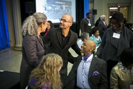 MIT professor of writing Junot Diaz converses with professor of linguistics Michel DeGraff (seated) and others at the annual Dr. Martin Luther King Jr. luncheon.